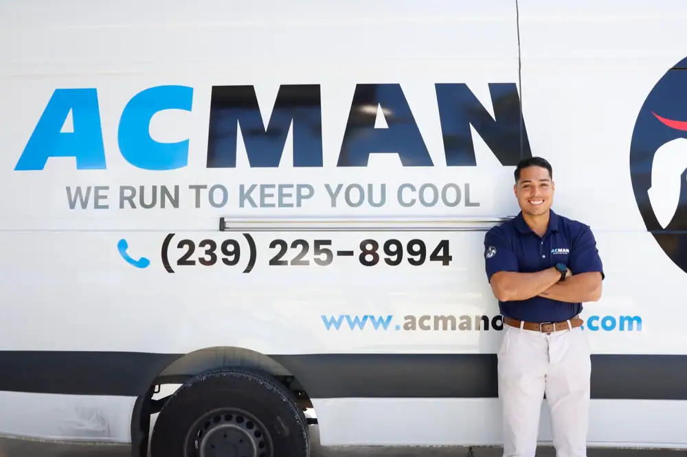 An ACMAN technician beside the giant ACMAN lettering on the van